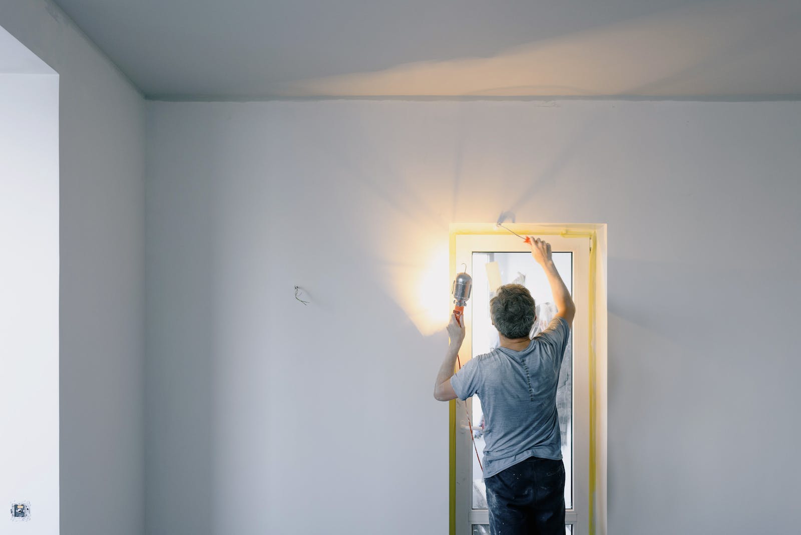 Faceless man repairing door in room