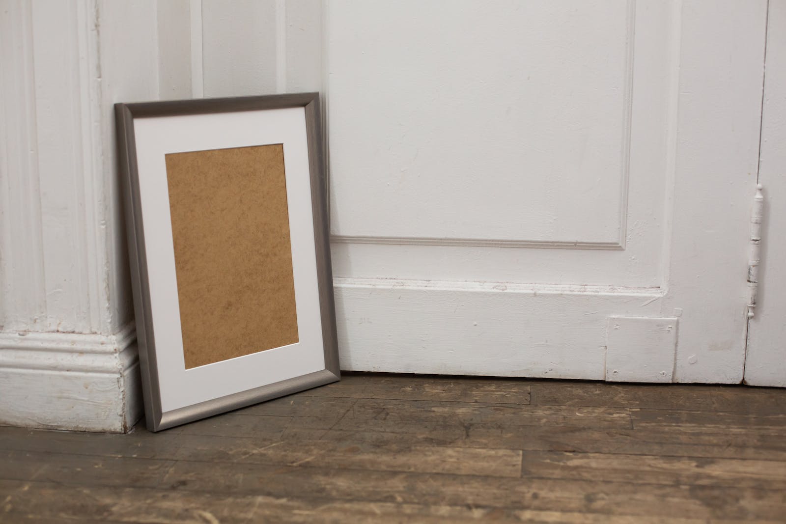 Empty carton frame placed on wooden floor near door